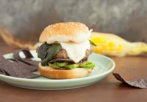 Santa Fe Burgers: One of my favorite burgers to toss on the grill in the summer. Topped with a spicy cheese sauce, roasted poblano peppers, and crispy blue corn chips! | macheesmo.com