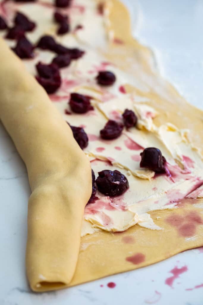 Rolling the cherry pastry into a roll.