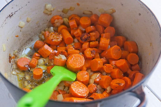 Cooking carrots and onions in a dutch oven.