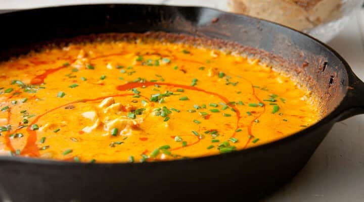 Cheesy Buffalo Chicken Dip baked in a skillet! This is a surprisingly easy dip made with real cheese and baked until piping hot. So addictive and always a crowd pleaser! | macheesmo.com