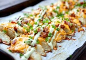 Loaded Potato Wedges - Appetizer? Side dish? Main meal? These completely loaded baked potato wedges can be anything you want. Cheddar, chives, and an avocado sour cream sauce. Potato perfection! | macheesmo.com