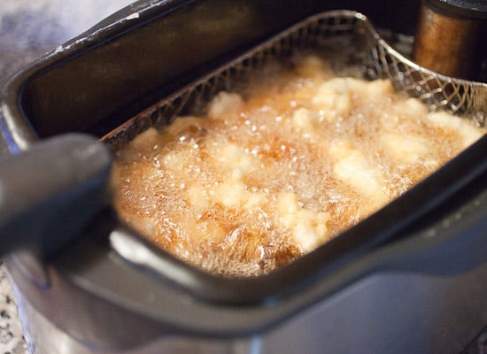 Frying chicken tempura in a deep fryer.