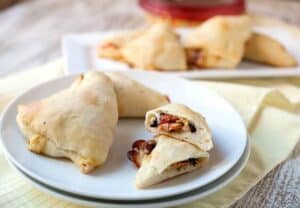 Hummus Pizza Pockets: A change-up on pizza! Perfect for a game-day appetizer. These bite-sized pizza pockets are stuffed with Mediterranean flavors like artichokes, olives, and tomatoes and have just enough hummus and cheese to act as a sauce. Fun to make and totally delicious! #sponsored | macheesmo.com