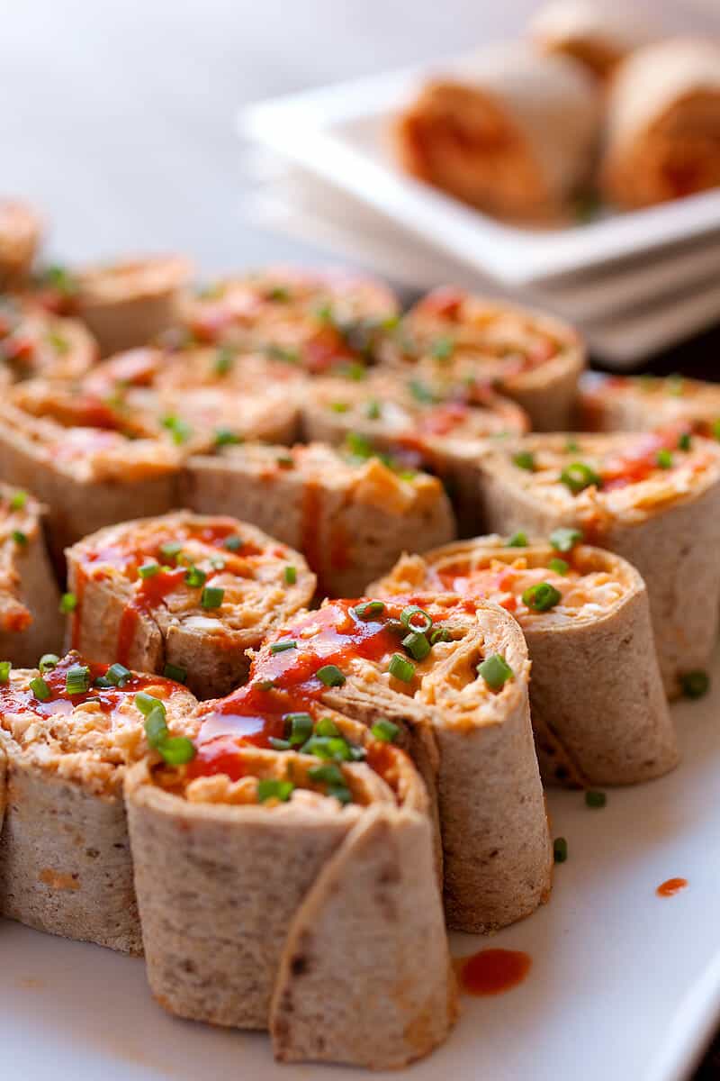 Buffalo Chicken Pinwheels: These are the perfect game day appetizer. Spicy and totally addictive, you need only five ingredients to make them happen and you can make them in advance! Use your favorite Flatout Flatbread to roll 'em up! #spons | macheesmo.com