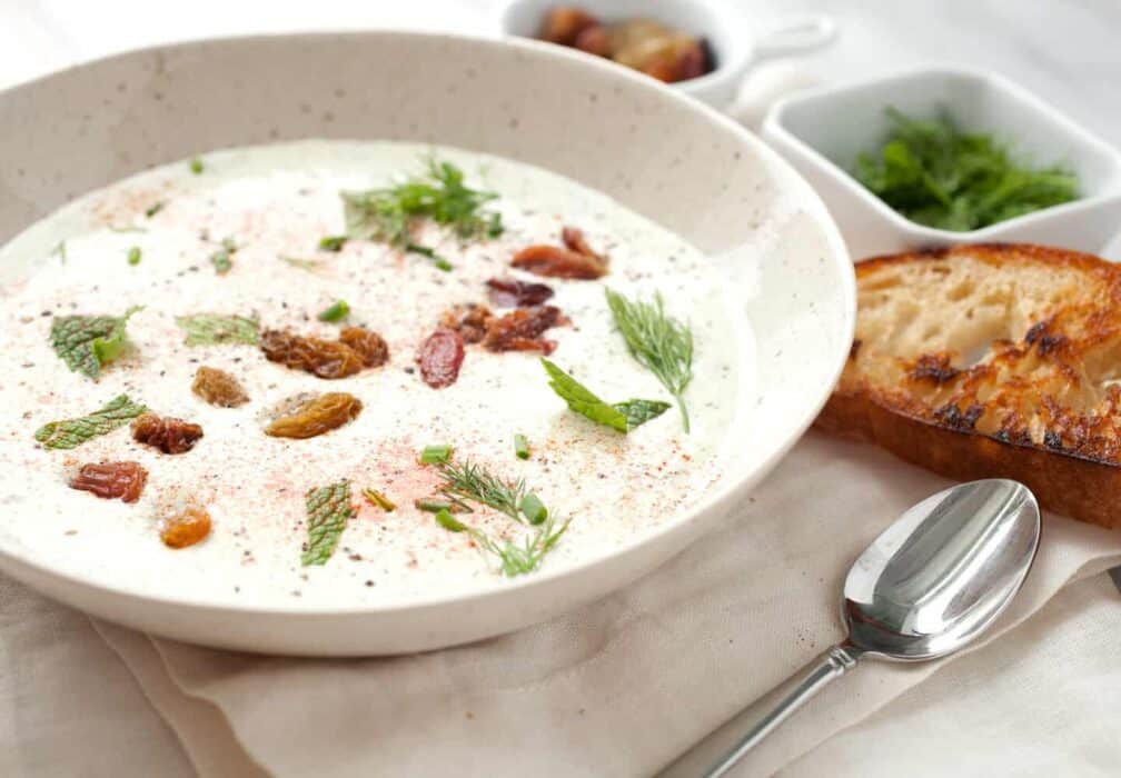 Chilled Yogurt Soup: Take the heat off with this easy to make blender cold yogurt soup! Topped with golden raisins, fresh herbs, and smoked paprika. It's best served with a big hunk of crusty bread! | macheesmo.com