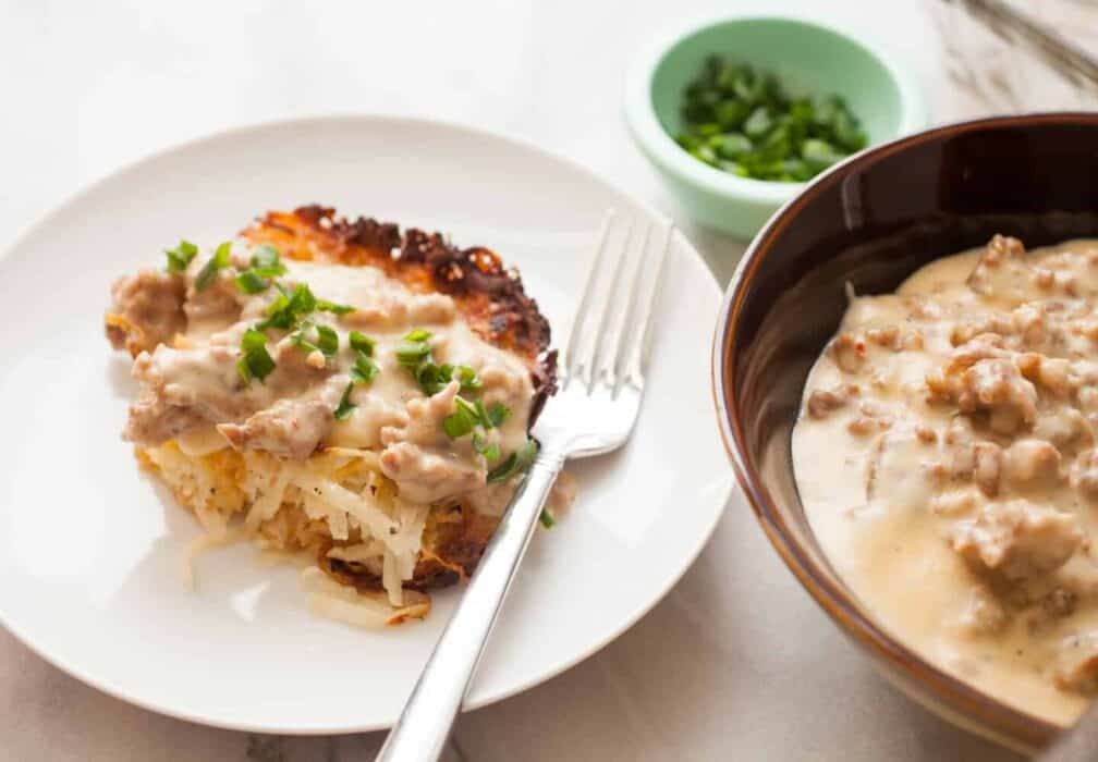 Potato Casserole with Sausage Gravy: This is slow comfort food at its best. Homemade simple potato casserole with fresh potatoes topped with a hearty sausage gravy. Comfort food on a plate! | macheesmo.com