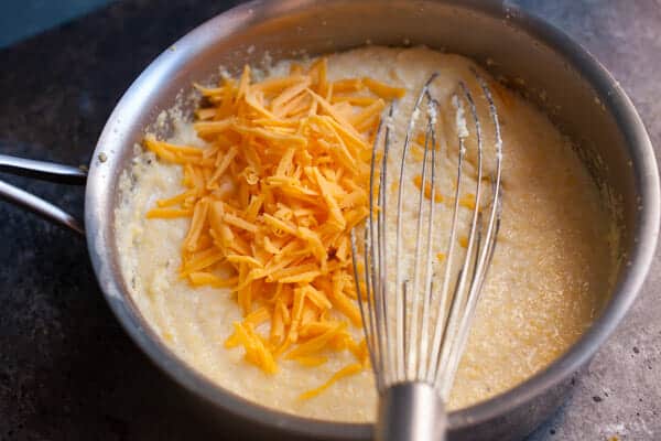 Adding cheddar cheese to polenta.