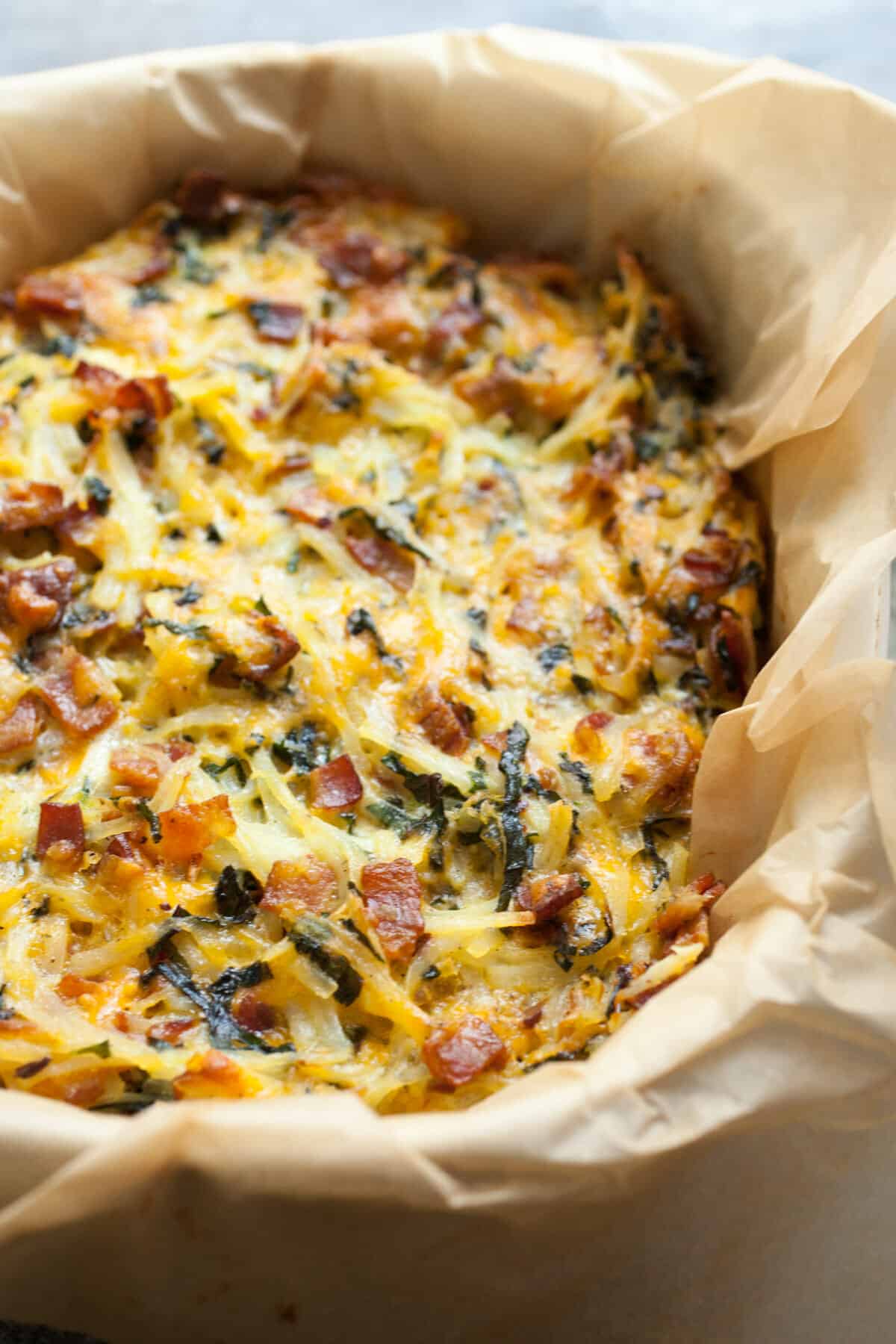 Potato Breakfast Pie with Bacon and Kale: An all-in one Brunch masterpiece, this pie is everything you want in a breakfast dish. Shredded potatoes, bacon, veggies, and just enough cheese and egg to hold it together. Make it, eat it, freeze any leftovers! | macheesmo.com