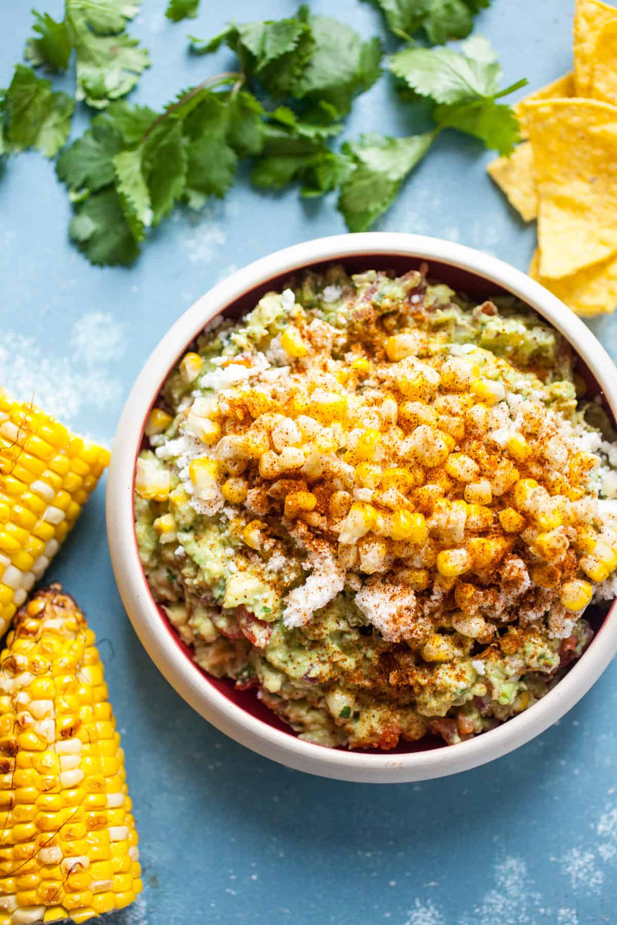 Street Corn Guacamole: Homemade guacamole mixed with a few simple, but perfect add-ins that mimic Mexican street corn (elote)! Roasted corn, cotija cheese, chili powder, cilantro, and a few other goodies. Perfect for a party! | macheesmo.com