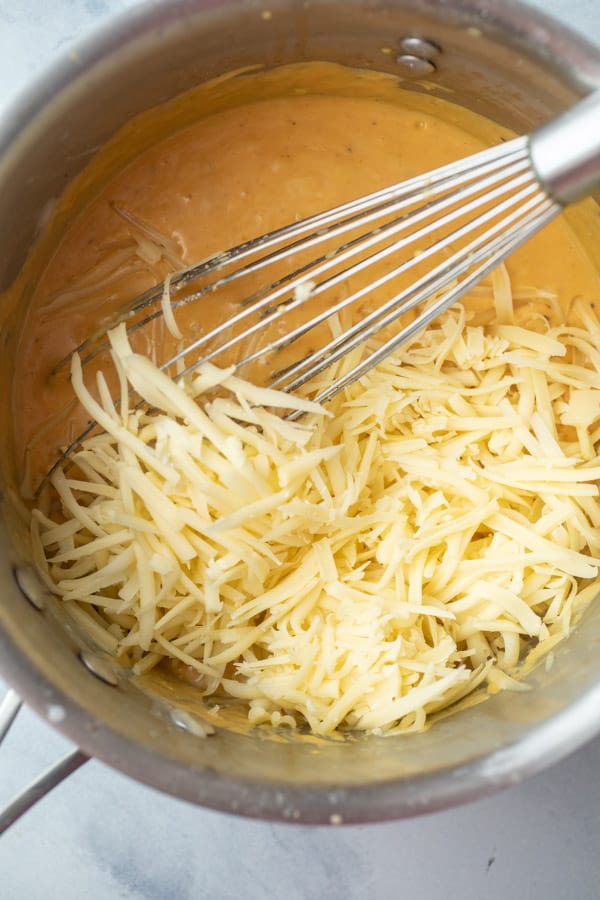 Adding cheese to the sauce.