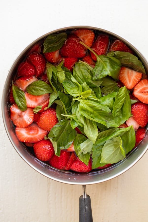 Cooking strawberry basil syrup in a pot.