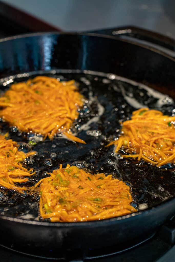 Frying sweet potato fritters in cast iron skillet.