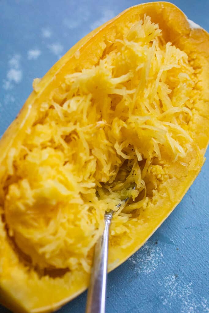 Scrapping out the tender spaghetti squash flesh.