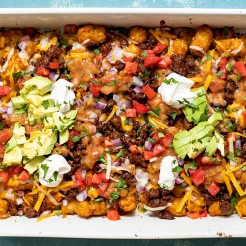 Tater Tot Nachos! It's exactly what you're thinking. Baked Tater Tots topped with cheese, green chile sauce, chorizo, and all the traditional nacho toppings! macheesmo.com